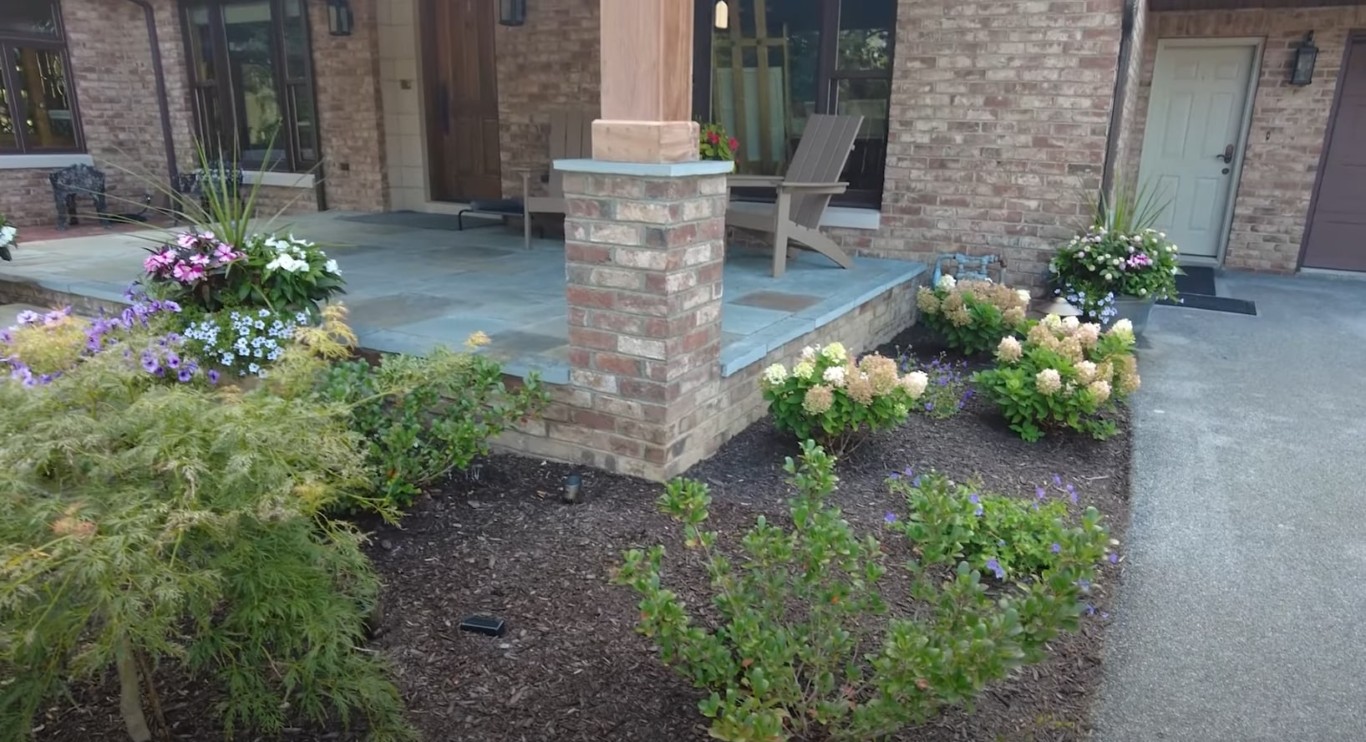 Professional landscaping featuring beautiful hardscape patio and flowering plants in Lynwood, CA